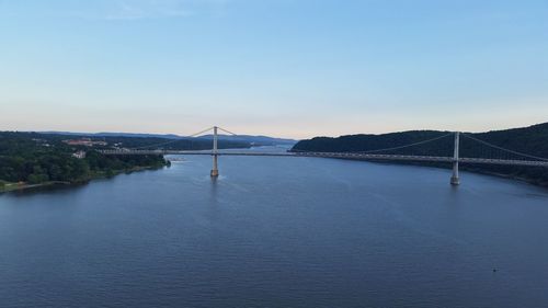 View of suspension bridge over river against sky