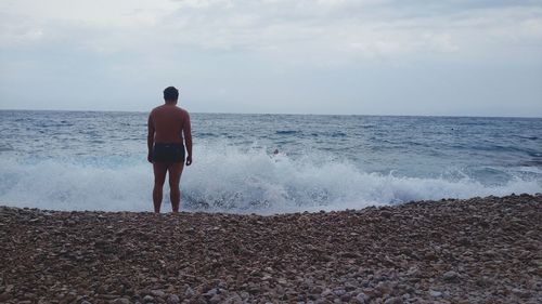 Rear view of man standing on beach