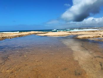 Scenic view of beach against blue sky