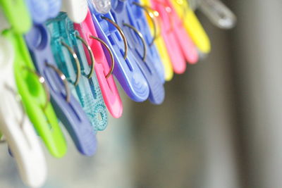 Close-up of colorful clothespins hanging indoors