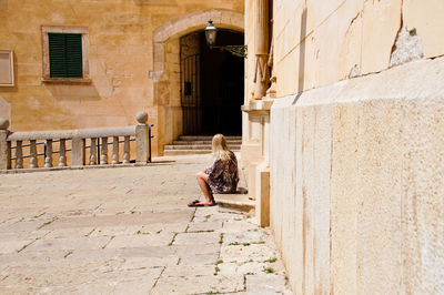 Woman sitting outside building