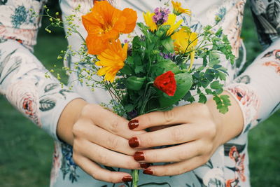 Midsection of woman holding flower bouquet