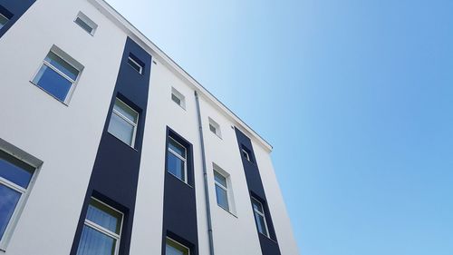 Low angle view of modern building against clear blue sky