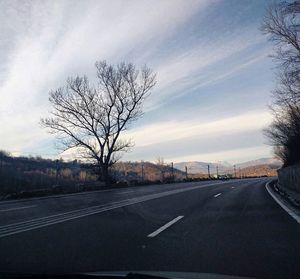 Road by tree against sky