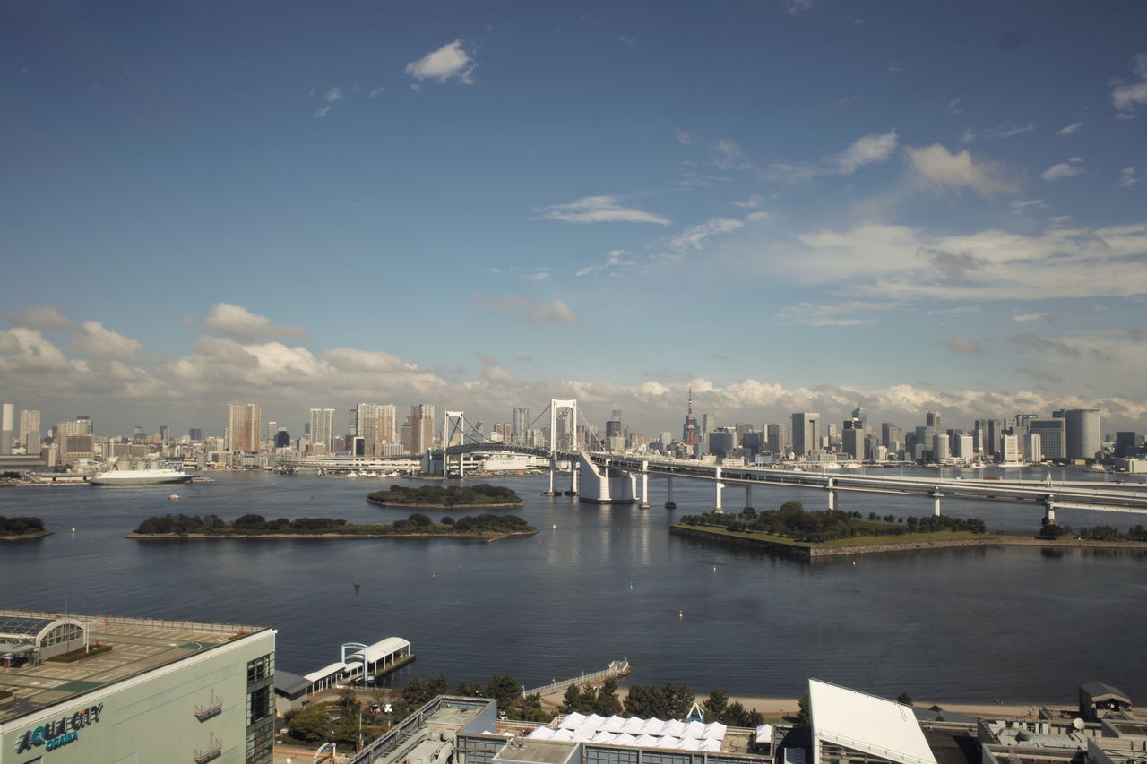 architecture, building exterior, built structure, city, water, harbor, nautical vessel, cityscape, transportation, sky, river, mode of transport, sea, commercial dock, boat, moored, cloud - sky, cloud, day, skyscraper