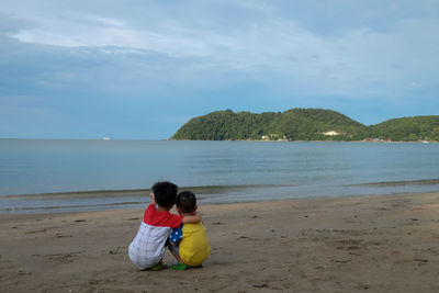 Rear view of women on beach against sea