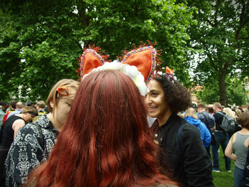 Young woman smiling while standing on tree