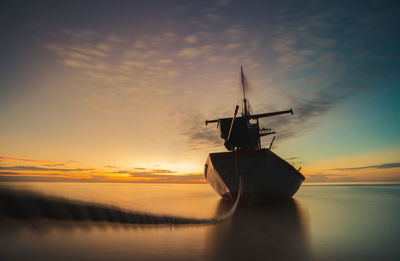 Ship in sea against sky during sunset