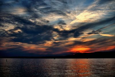 Silhouette of seascape and mountain against sky