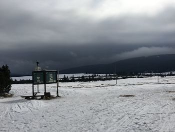 Scenic view of snow covered field against sky