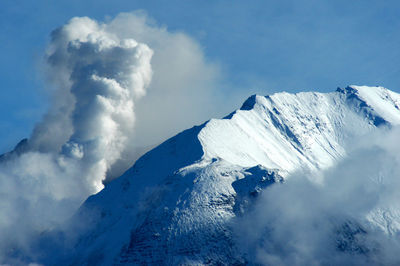 Low angle view of snowcapped mountains against sky