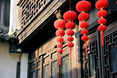 Low angle view of lanterns hanging by window of traditional house