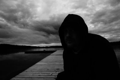 Portrait of silhouette man standing by lake against sky