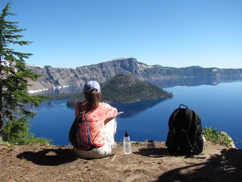 Rear view of woman looking at mountains against clear sky