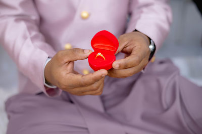 Midsection of man holding dentures