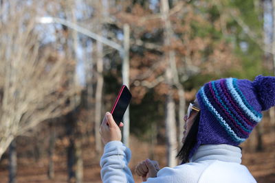 Close-up of woman wearing knit hat photographing outdoors