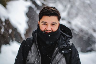 Portrait of young man standing in snow