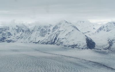 Scenic view of snow covered mountains against sky