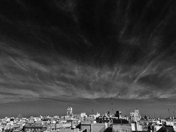 Buildings in city against cloudy sky