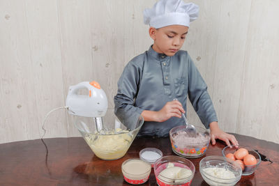 Boy mixing flour in bowl