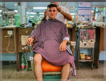 Hairdresser cutting man hair at barber shop