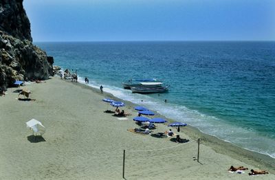 Panoramic view of people on beach against clear sky