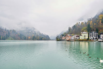 Scenic view of lake by buildings against sky