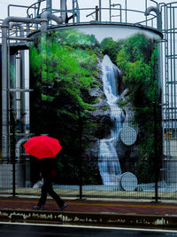 Woman walking on wet road during rainy season