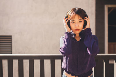Portrait of a girl standing against railing