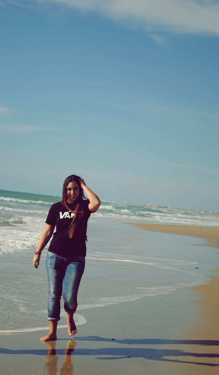 beach, sea, water, lifestyles, leisure activity, shore, horizon over water, person, casual clothing, full length, standing, sky, sand, childhood, vacations, young adult, elementary age, young women