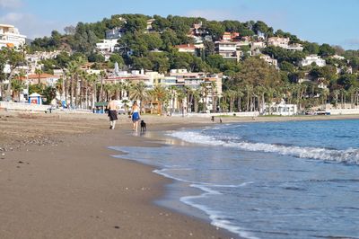 People on beach by buildings in city