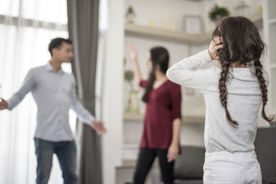 Daughter looking at parents fighting in house