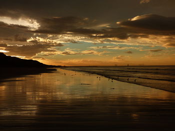 Scenic view of coastline against cloudy sky