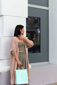 Side view of young woman looking through window