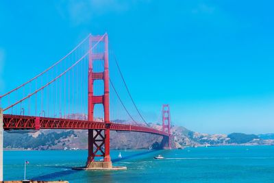 Golden gate bridge over sea against blue sky