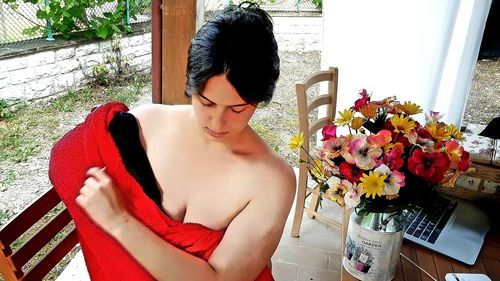 Midsection of woman standing by potted plant