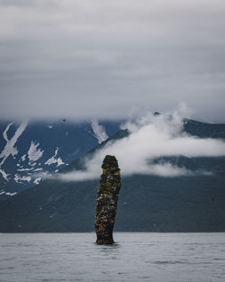 Woman standing on mountain against sky