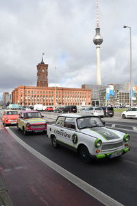 Cars on road by buildings in city