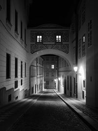 View of a lonely street with buildings and arch at nigh in prague