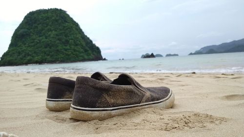 High angle view of shoes on beach against sky