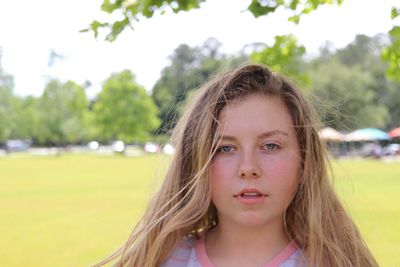 Portrait of young woman standing in park