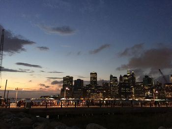 Illuminated buildings against sky during sunset