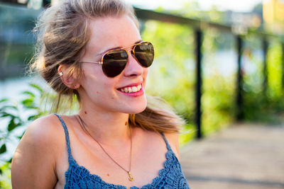 Portrait of young woman wearing sunglasses standing outdoors