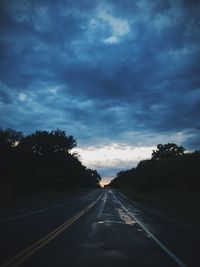 Country road against cloudy sky