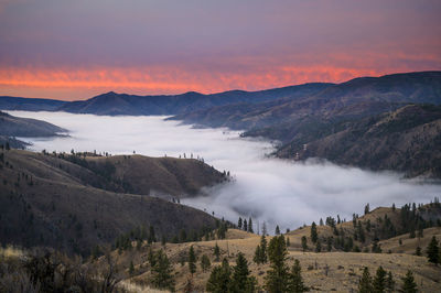 Pink sunrise in the mountains with clouds in the valley
