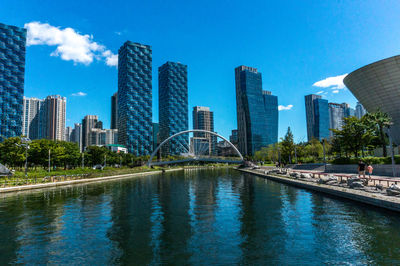 View of swimming pool by buildings against blue sky