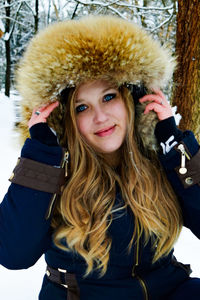 Portrait of smiling woman standing in snow