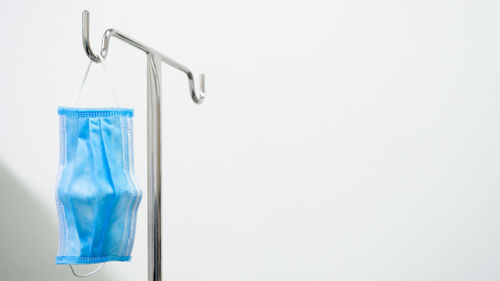 Close-up of blue metal hanging against white background