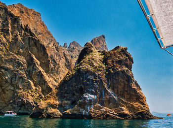 Scenic view of rocks in sea against clear sky