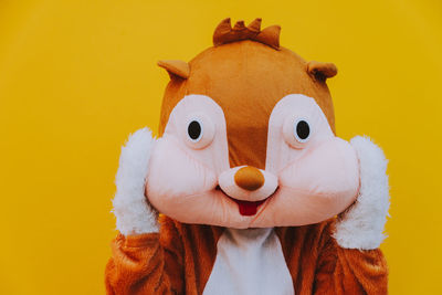 Close-up of squirrel gesturing against yellow background